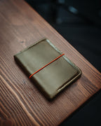 The Adventurer | Gloss in Serpentine Green with orange elastic after a year of daily carry